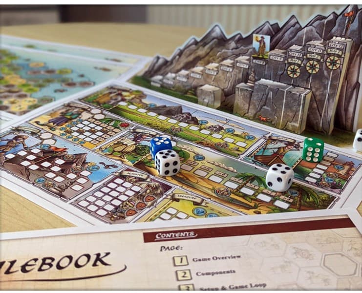 A detailed board game setup with colorful cards, dice, and components on a table. Inspired by Wayfarer's Tale, the game features a mountain-themed backdrop and a map-like board. Distinct sections for gameplay elements are included, with a rulebook partially visible in the foreground.