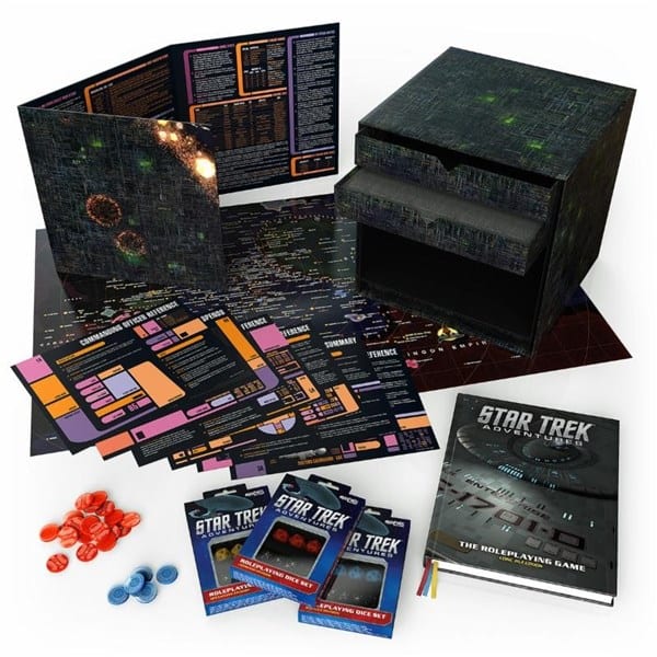 This Modiphius Star Trek RPG set includes a space-themed box, game books, maps, character sheets, dice sets, and various game tokens—all meticulously organized to create an immersive experience. Dive into the universe with a Borg Cube-inspired adventure waiting inside.