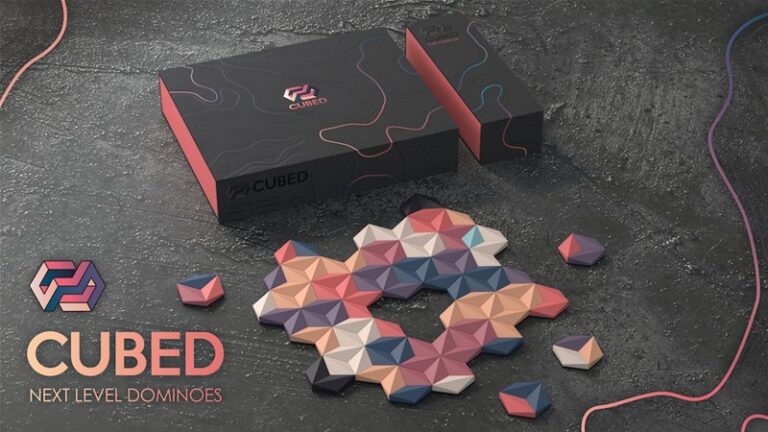 A set of Cubed Next Level Dominoes rests on a textured surface, showcasing colorful geometric shapes. The sleek packaging, in black and pink hues with abstract designs, highlights the Kickstarter-backed innovation. "CUBED Next Level Dominoes" is prominently displayed on the left.