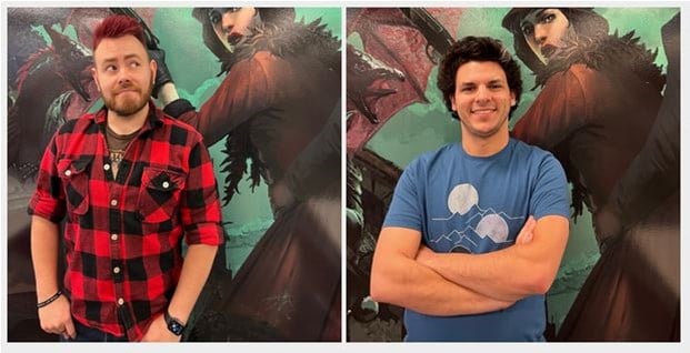 Two people stand before a mural of an Arkham Horror character, clad in red and black. The one on the left sports a red plaid shirt, while the other wears a blue mountain-themed shirt. Both smile, capturing the essence of Fantasy Flight's imaginative world.