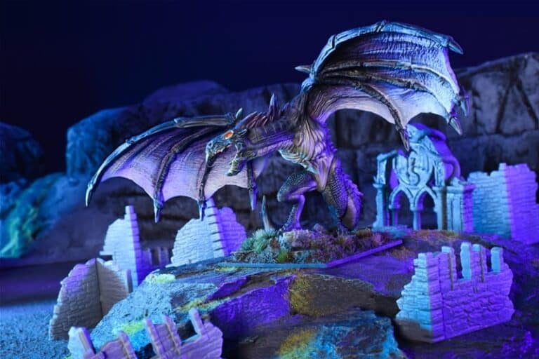 A fantastical dragon sculpture with outstretched wings stands in a ruined landscape, reminiscent of epic Dungeon Adventures. It's illuminated by dramatic blue and purple lighting, surrounded by broken stone structures and rugged terrain.