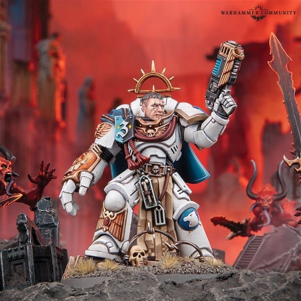 A detailed miniature figure of Captain Messinius in white and gold armor stands on a rocky base, surrounded by a fiery backdrop and demonic figures. The character wields a weapon with commanding flair, his blue cape billowing behind him alongside a halo-like headpiece.