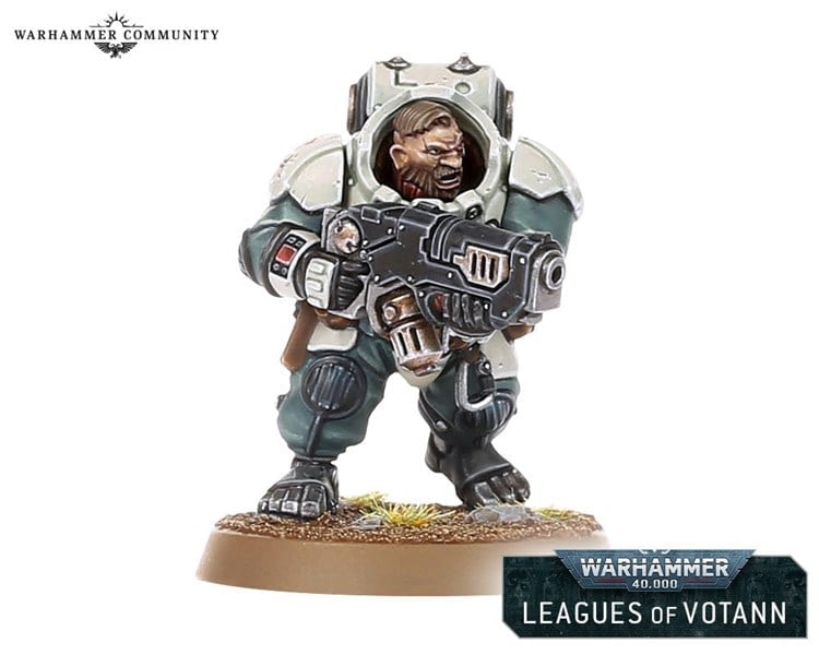 A detailed miniature figure from Warhammer 40k's Leagues of Votann, featuring a Squat warrior in green and gray armor, holding a large weapon and standing on a base with grass.