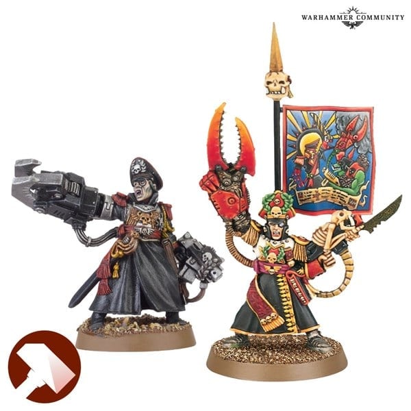 A painted miniature set from Games Workshop features two characters: an Imperial Guard commander holding a large gun and wearing a dark robe, and another adorned in colorful attire with a claw weapon and a banner displaying vibrant imagery. Both stand on textured bases.