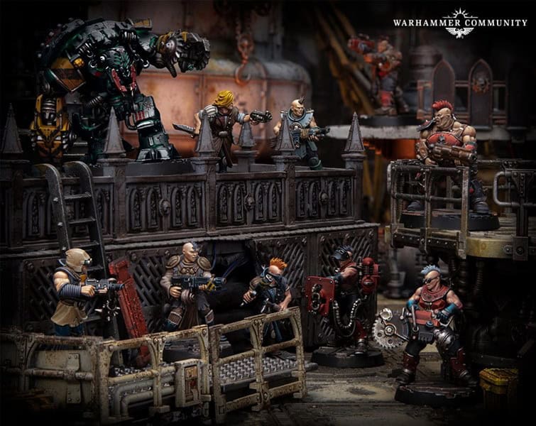 Miniature figures in a detailed industrial diorama depict a sci-fi battle scene from the Necromunda universe. Characters in diverse armor and weaponry are positioned on metal platforms and walkways. A large robot overlooks the scenario, with gothic architecture in the background, echoing Games Workshop's iconic style.