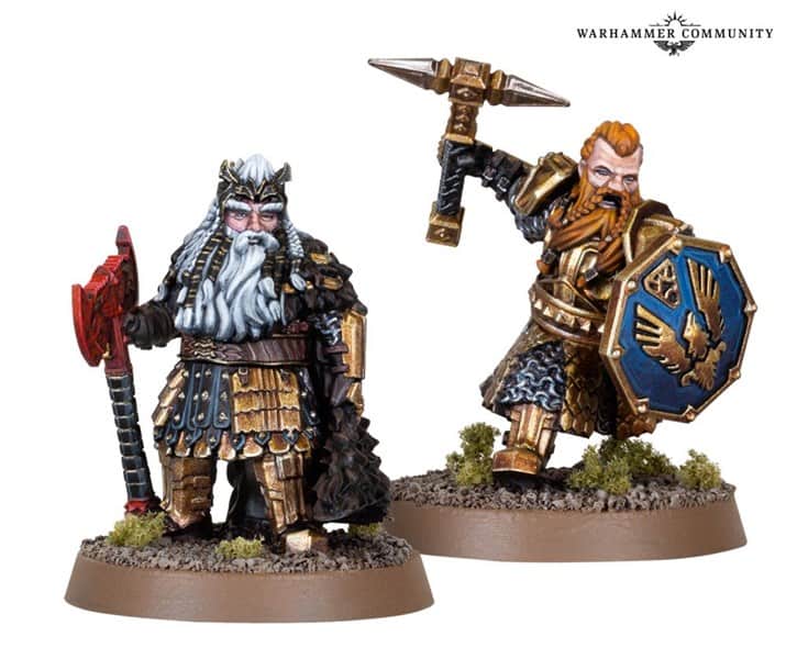 Two detailed miniature figures of fantasy warriors from Games Workshop, one with white hair and an axe, the other with red hair, a hammer, and a shield. Dressed in ornate armor, they stand on grassy bases against a white background featuring the "Warhammer Community" logo.