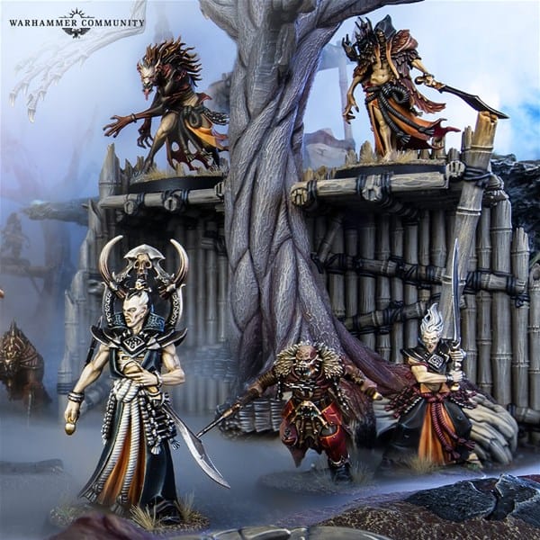 Fantasy miniatures are posed in an elaborate diorama, featuring Soulblight Vampires from Games Workshop's Warcry. Armored figures with intricate designs and monstrous faces stand on and around a wooden structure and a large tree. The scene is rich with detail and dramatic poses.