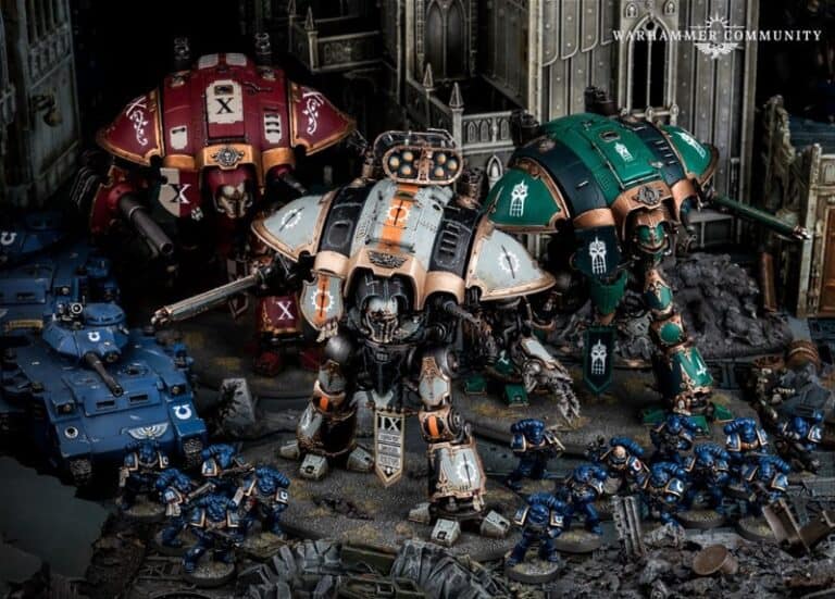 Two large mech warriors with intricate designs dominate the futuristic battle scene, reminiscent of a 40k universe. Knights stand surrounded by miniature armored soldiers and vehicles, set against a detailed, dystopian urban backdrop. The scene is part of a captivating Games Workshop tabletop display.