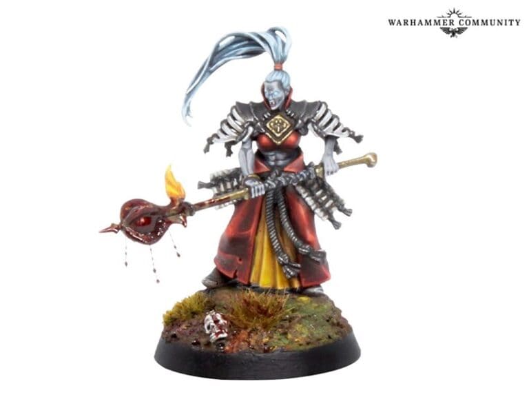 A fantasy miniature figure of a warrior with blue skin and a topknot hairstyle, wearing red and black armor. Resembling a fierce Warcry Bloodhunt character, the figure holds a staff with a flaming ornament and stands on a detailed base adorned with grass and an eerie skull.