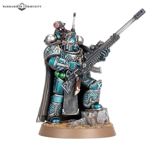 A detailed miniature figure of a sci-fi soldier in blue and silver armor, reminiscent of the Horus Heresy era, holding a large rifle. The figure stands on a rocky base with a cape billowing behind. The helmet features optics, and there's a logo above indicating "Warhammer Community.