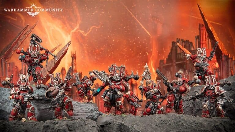 A group of intricately painted Khorne Berserkers in red and black armor, posed for battle atop rocky terrain. The background features a fiery, apocalyptic landscape with towering, blazing structures and streaks of orange and yellow across the sky—a showcase worthy of Games Workshop previews.