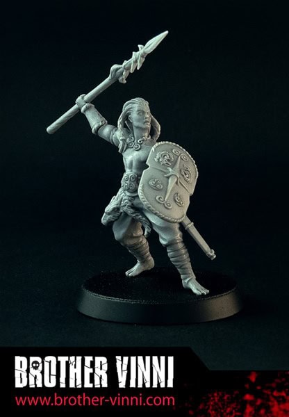 A grayscale miniature figurine of Cuchulainn, a warrior from SAGA, stands on a round base, gripping a spear and shield adorned with ornate designs. At the bottom, "BROTHER VINNI www.brother-vinni.com" is inscribed.