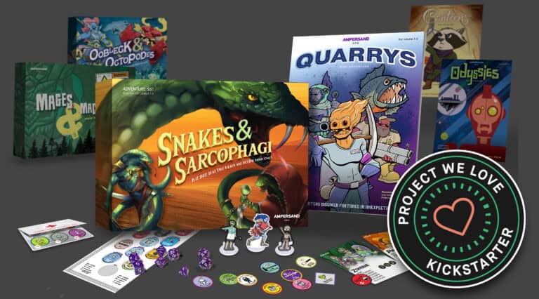 A vibrant collection of board games graces the tabletop, showcasing titles like "Snakes & Sarcophagi" and "Quarrys." Game pieces mingle with promotional materials as a "Project We Love" Kickstarter badge gleams in the corner, capturing the thriving spirit of tabletop gaming.