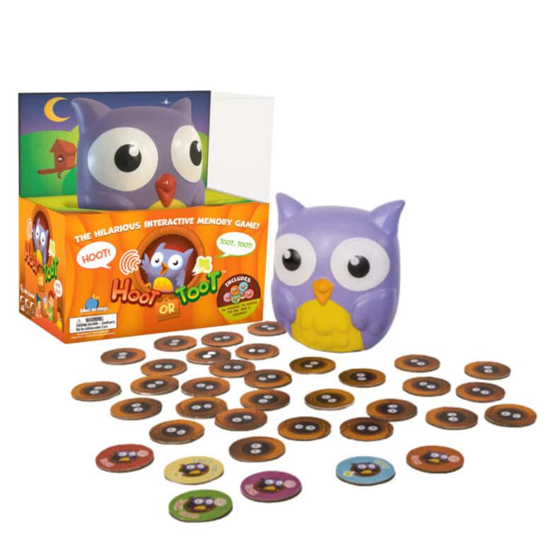 The image showcases a boxed game set from the 2023 Collection titled "Hoot or Toot," featuring a purple and yellow owl figure. Designed by Blue Orange Games, it includes several round game tokens with various printed designs, making it perfect for family-friendly gaming fun.