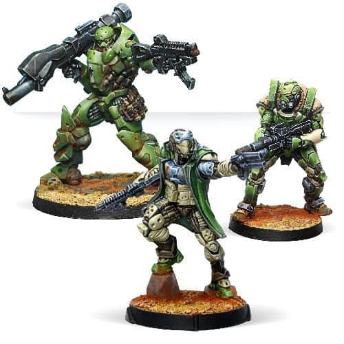 Three miniature sci-fi soldiers in detailed armor, part of the new products from Corvus Belli's Infinity line, stand on separate bases. The figures are equipped with futuristic weapons, and their armor features intricate designs in shades of green, brown, and metallic hues.