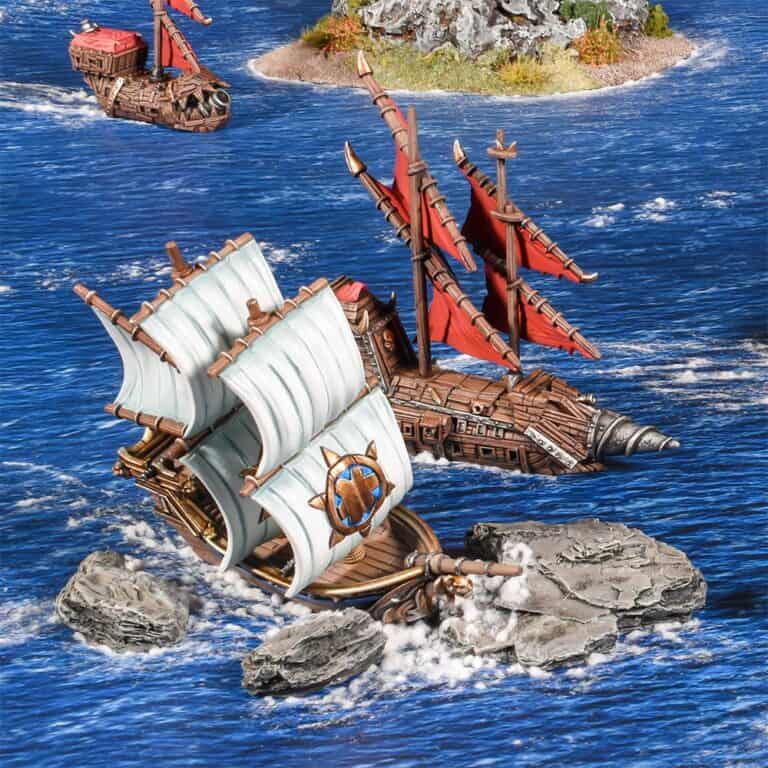 Two model ships with detailed sails and wooden hulls are in a blue ocean setting. Part of this armada, one ship has white sails with a compass decoration, navigating around rocky terrain, while a red-sailed companion looms in the background.