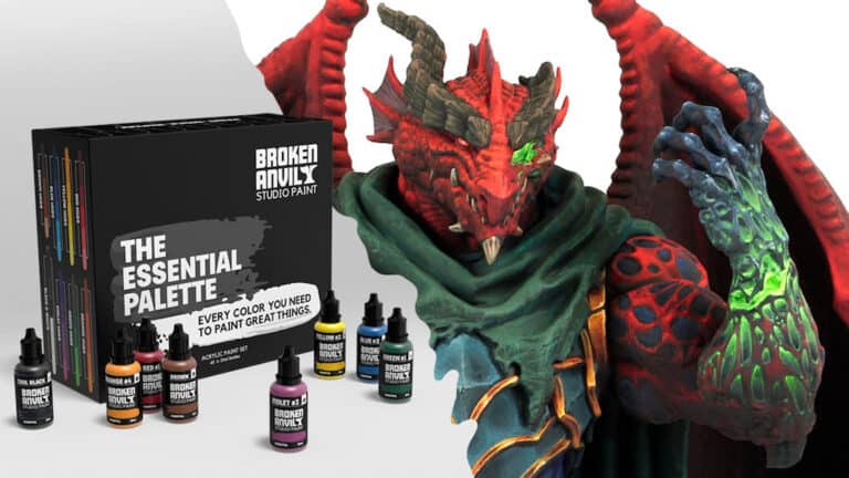 A boxed set of Broken Anvil Studio Paint, labeled "The Essential Palette," is displayed alongside several paint bottles. On a Friday, the vibrant red and green dragon figurine showcases snippets of the paint's stunning effects.