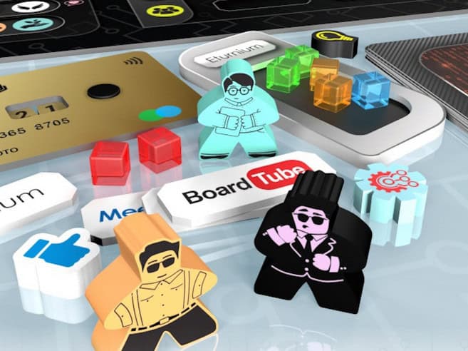 Various board game pieces, including colorful meeples and cubes, are arranged on a surface with tech-themed elements like a credit card and app icons. Labels like "BoardTube" and "Ethereum" evoke a modern Silicon Valley aesthetic, perfect for the next big Kickstarter project.