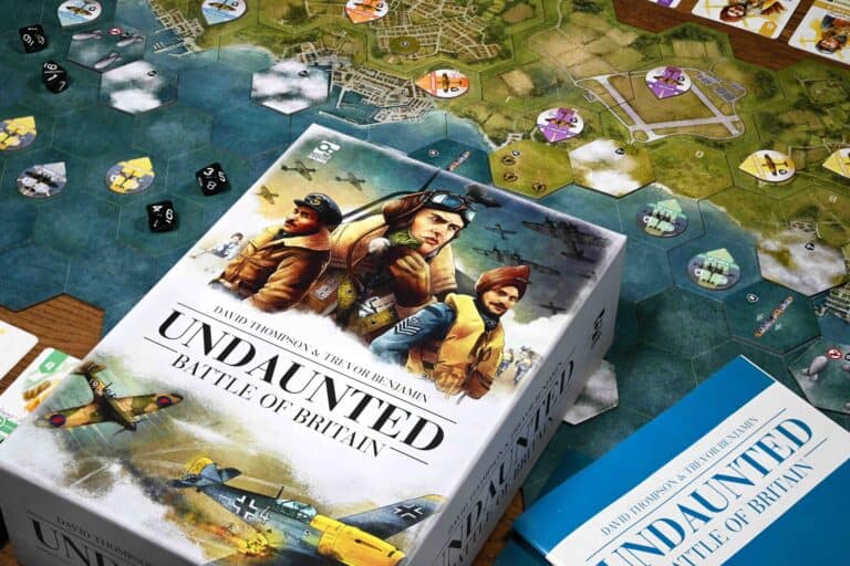 The box cover and components of the board game "Undaunted: Battle of Britain" from Osprey Publishing are displayed. The cover features pilots in uniform and aircraft, while the board shows a detailed map with grid overlays and round tokens.