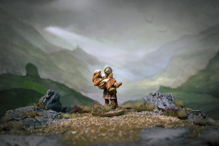 A small figurine of a medieval knight stands in a rocky landscape, reminiscent of Jon Hodgson's style, holding a lamb under each arm. Sunlight breaks through the clouds, casting a gentle spotlight on the figure. The scene unfolds like miniature landscape backdrops painted in muted green and gray tones.