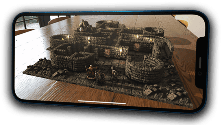 A smartphone showcases an augmented reality scene of a small stone castle with figures on a wooden table, reminiscent of Paizo's Starfinder universe. The screen captures a detailed, illuminated 3D model positioned as if it were physically present on the table's surface.