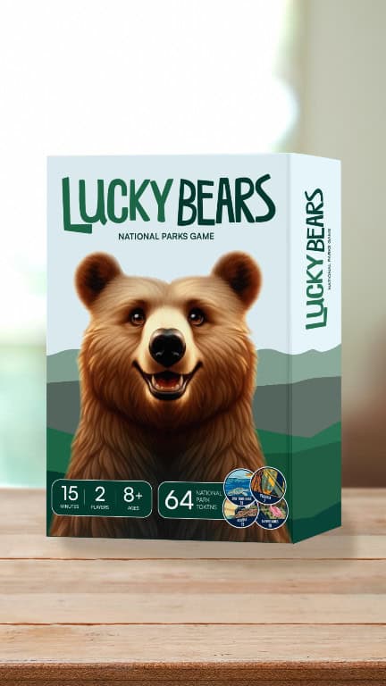 The image displays the "Lucky Bears: National Parks Game" board game box, depicting a smiling bear. It offers a 15-minute playtime for 2 players, ages 8+, along with 64 national park tokens, perfect for celebrating National Park Week. The box rests on a wooden surface.