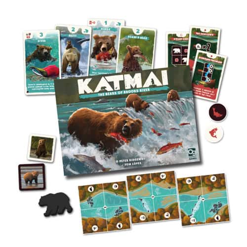 Board game components for "Katmai: The Bears of Brooks River" displayed, featuring a striking game box with a bear deftly catching a fish in the Brooks River, alongside cards adorned with bear images, and an assortment of tokens and tiles.