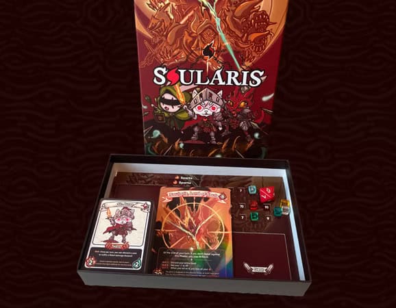 Board game titled "Soularis" with a dragon-themed cover art brings an epic fantasy to life. The Kickstarter-backed game box is open, revealing cards, a game board, and various dice inside, all adorned with colorful, fantasy-inspired illustrations that ignite the imagination of any rebel hero.