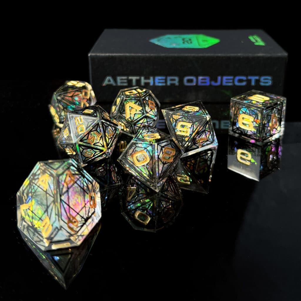 A set of iridescent Cathedral Dice with numbers, including D20 and D6, displayed on a reflective black surface. The dice, inspired by Gothic architecture, are in front of a box labeled "Aether Objects." Their colors range from gold to rainbow hues.
